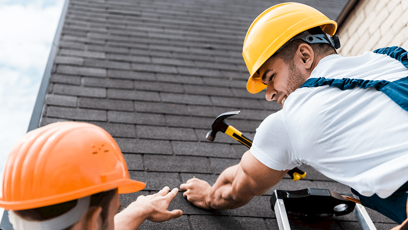 Roofer repairing damaged roof tiles on house - request a quote